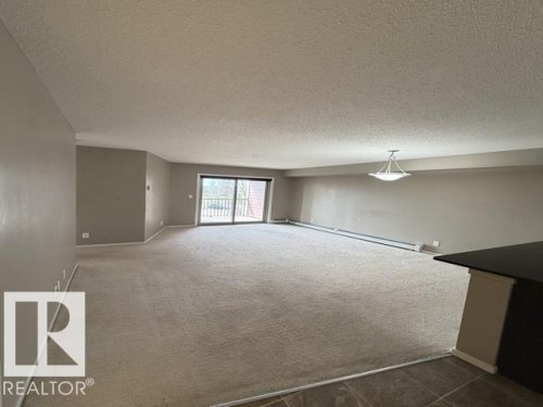 Spacious living area featuring neutral carpeting and light gray wall tones - 321 107 Watt Common, Edmonton, AB - Indoor Photo Showing Other Room