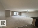 Spacious living area featuring neutral carpeting and light gray wall tones - 321 107 Watt Common, Edmonton, AB  - Indoor Photo Showing Other Room 