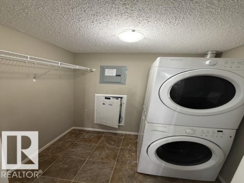 Laundry area featuring tile flooring, neutral wall paint, and overhead lighting - 321 107 Watt Common, Edmonton, AB - Indoor Photo Showing Laundry Room