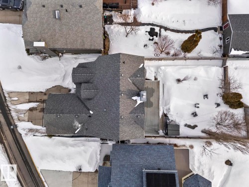 Aerial view of the property showcasing a gray shingle roof, paved driveway, and surrounding grounds - 515 Lakeshore Drive, Cold Lake, AB - Outdoor