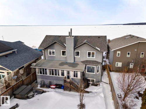 The property features a private backyard with a hot tub and a deck area, enclosed by a wooden fence - 515 Lakeshore Drive, Cold Lake, AB - Outdoor With Exterior