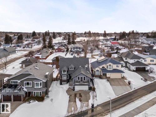 This property features a two-story design with a dark gray exterior and a matching dark gray roof, situated on a sloped lot - 515 Lakeshore Drive, Cold Lake, AB - Outdoor