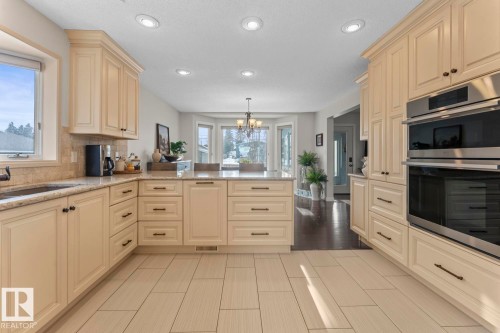 The kitchen features light-colored cabinetry with dark hardware, a center island with a light-colored countertop, and stainless steel built-in ovens - 515 Lakeshore Drive, Cold Lake, AB - Indoor Photo Showing Kitchen