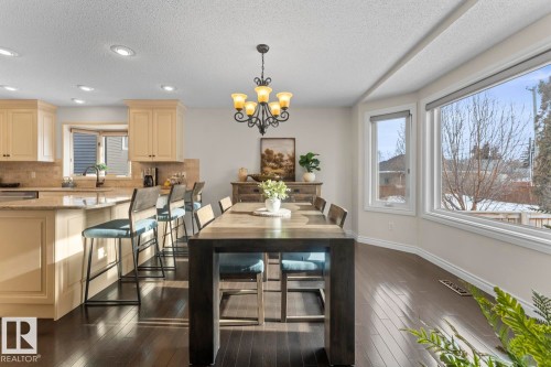 Open concept kitchen and dining area featuring dark hardwood floors, cream cabinetry, recessed lighting, and a bay window - 515 Lakeshore Drive, Cold Lake, AB - Indoor Photo Showing Dining Room