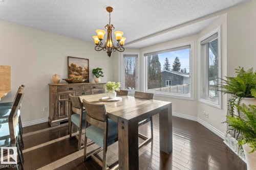 The dining area features dark hardwood floors and a bay window providing natural light - 515 Lakeshore Drive, Cold Lake, AB - Indoor Photo Showing Dining Room