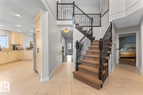 The property features a staircase with dark wood railings and balusters, carpeted treads, and a landing - 515 Lakeshore Drive, Cold Lake, AB - Indoor Photo Showing Other Room
