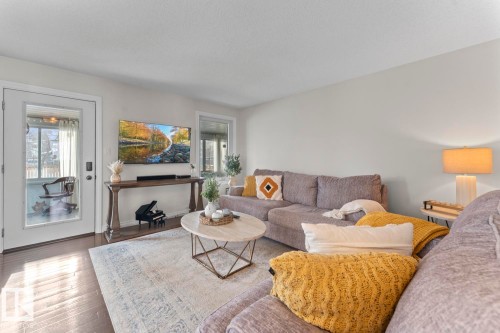 Living room featuring hardwood floors, a large area rug, and a glass-paneled door - 515 Lakeshore Drive, Cold Lake, AB - Indoor Photo Showing Living Room