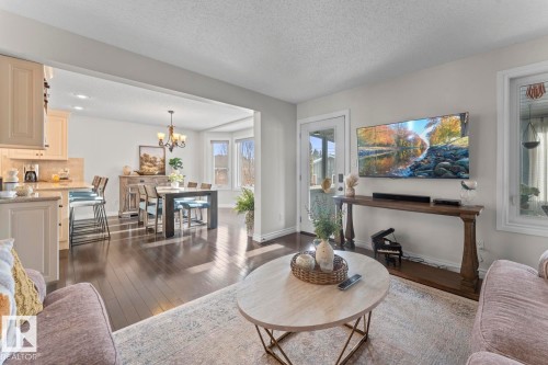 This inviting living area features dark wood flooring, light-colored walls, and a large window providing natural light - 515 Lakeshore Drive, Cold Lake, AB - Indoor Photo Showing Living Room