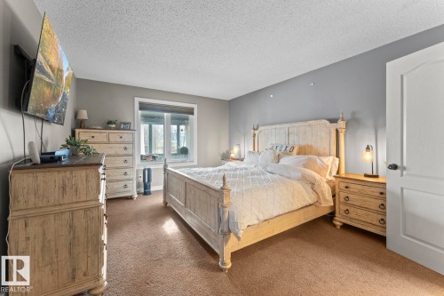 This room features soft brown carpeting, a window providing natural light, and walls painted in a light grey hue - 515 Lakeshore Drive, Cold Lake, AB - Indoor Photo Showing Bedroom