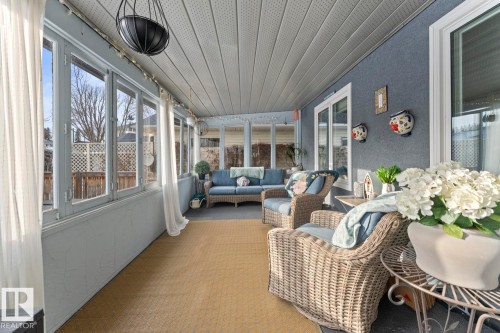 This enclosed porch features extensive windows, a textured ceiling, and a light-colored floor - 515 Lakeshore Drive, Cold Lake, AB - Outdoor With Deck Patio Veranda With Exterior