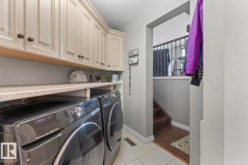 The property features a laundry area with white upper cabinetry, a light-colored countertop, and light-colored floor tiling - 515 Lakeshore Drive, Cold Lake, AB - Indoor Photo Showing Laundry Room