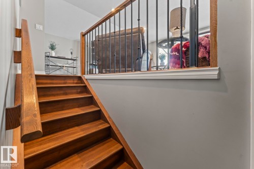 Staircase featuring rich wood treads and handrail with black metal balusters - 515 Lakeshore Drive, Cold Lake, AB - Indoor Photo Showing Other Room