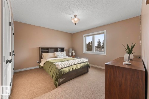 This bedroom features light brown walls, a window providing natural light, and a brown carpet - 515 Lakeshore Drive, Cold Lake, AB - Indoor Photo Showing Bedroom