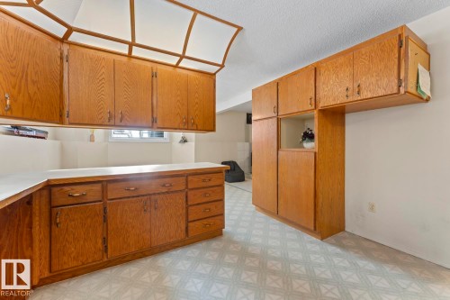 This kitchen features extensive wood cabinetry, white countertops, and patterned flooring - 515 Lakeshore Drive, Cold Lake, AB - Indoor Photo Showing Kitchen
