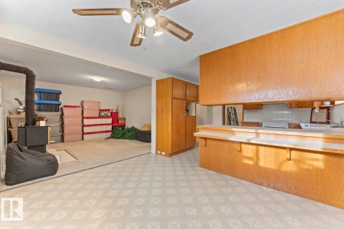 This property features a kitchen area with wood cabinetry, a breakfast bar, and a ceiling fan with integrated lighting - 515 Lakeshore Drive, Cold Lake, AB - Indoor Photo Showing Kitchen