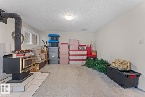 The property features a wood-burning stove with a tiled hearth and a window with blinds - 515 Lakeshore Drive, Cold Lake, AB - Indoor