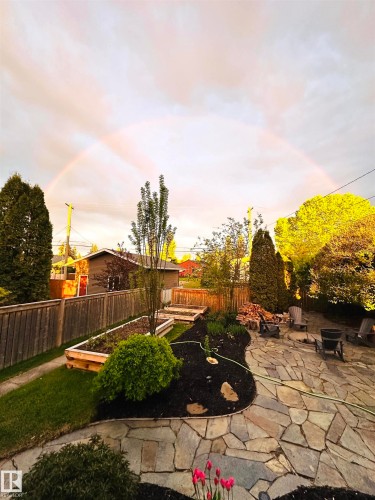 The property features a stone patio, raised garden beds, and mature trees - 515 Lakeshore Drive, Cold Lake, AB - Outdoor