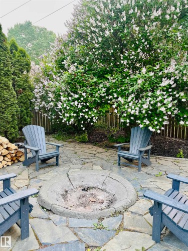 The property features an outdoor patio area with flagstone paving and a central fire pit - 515 Lakeshore Drive, Cold Lake, AB - Outdoor With Deck Patio Veranda
