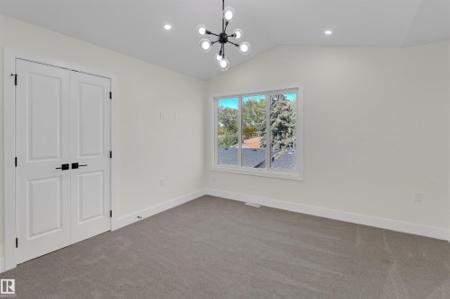 Vaulted ceiling with a modern chandelier and recessed lighting - 7936 91 Avenue, Edmonton, AB - Indoor Photo Showing Other Room