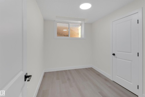 Interior room featuring light wood-finish flooring, white walls, and a white ceiling with a circular flush-mount light fixture - 7936 91 Avenue, Edmonton, AB - Indoor Photo Showing Other Room