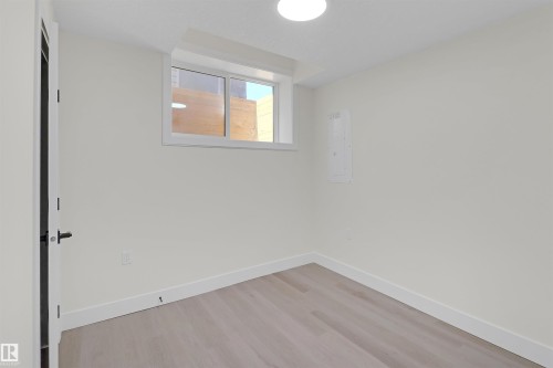 Room featuring a single window, light-toned wood-finish flooring, and white baseboards - 7936 91 Avenue, Edmonton, AB - Indoor Photo Showing Other Room