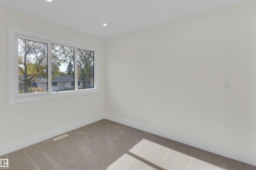 Bright room featuring a three-pane window, neutral-toned carpet, recessed lighting, white baseboards, and light-colored walls - 7936 91 Avenue, Edmonton, AB - Indoor Photo Showing Other Room
