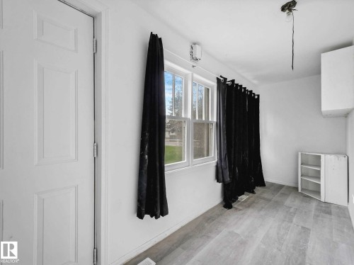 Room featuring wood-finish flooring, white walls, and multiple windows - 4322 53 Street, Wetaskiwin, AB - Indoor Photo Showing Other Room