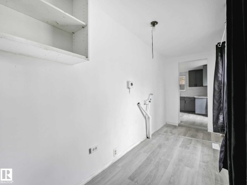 Utility area featuring wood-finish flooring, white walls, and an overhead lighting fixture - 4322 53 Street, Wetaskiwin, AB - Indoor Photo Showing Other Room