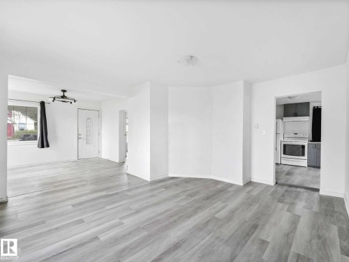 Spacious living area featuring light wood-finish flooring and white walls - 4322 53 Street, Wetaskiwin, AB - Indoor