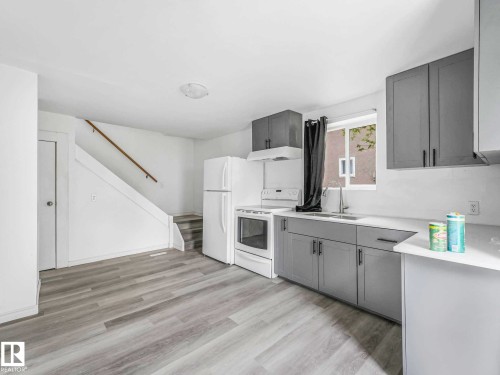 Contemporary kitchen featuring gray shaker-style cabinetry, white countertops, and white appliances - 4322 53 Street, Wetaskiwin, AB - Indoor Photo Showing Kitchen