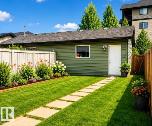 Green siding building with a white door, featuring a window and exterior light fixture - 225 51A Street, Edmonton, AB 