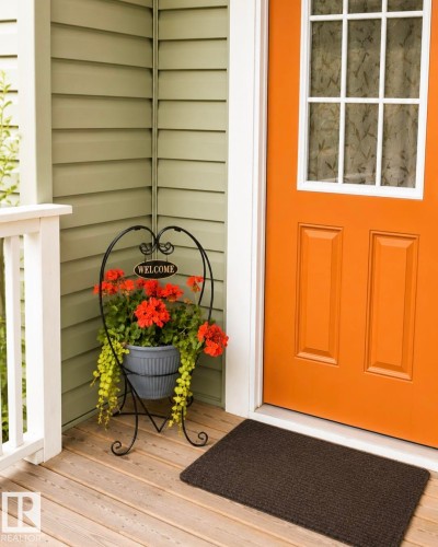 Front porch entry featuring a bright orange paneled door with divided light window - 225 51A Street, Edmonton, AB 