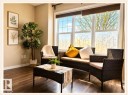 Spacious interior room featuring expansive windows with roller shades, wood-finish flooring, and light-toned wall paint - 225 51A Street, Edmonton, AB 