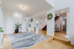 Entryway featuring light wood-finish flooring, recessed lighting, and a modern ceiling light fixture - 