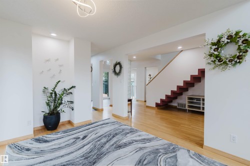 Interior architectural features include a contemporary staircase with red-finished risers, light wood-finish flooring, and recessed ceiling lighting - 342 O'Connor Close, Edmonton, AB - Indoor