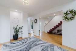 Interior architectural features include a contemporary staircase with red-finished risers, light wood-finish flooring, and recessed ceiling lighting - 