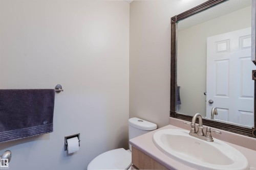 Bathroom vanity featuring an oval undermount sink, brushed nickel faucet, and a framed mirror - 342 O'Connor Close, Edmonton, AB - Indoor Photo Showing Bathroom