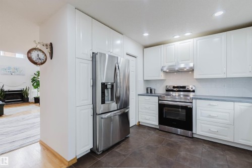 Modern kitchen featuring white cabinetry, stainless steel appliances, dark tile flooring, light countertops, and recessed lighting - 342 O'Connor Close, Edmonton, AB - Indoor Photo Showing Kitchen