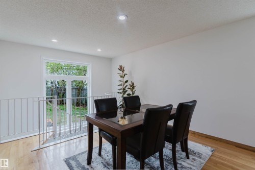 Bright dining area featuring light wood-finish flooring, recessed lighting, and a white railing overlooking a lower level - 342 O'Connor Close, Edmonton, AB - Indoor