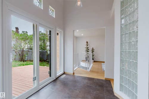 Spacious entry area with dark tile flooring, a curved glass block wall, and high ceilings - 342 O'Connor Close, Edmonton, AB - Indoor Photo Showing Other Room