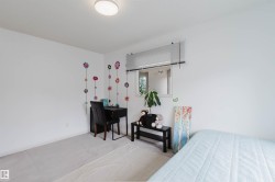 Room featuring light-toned carpet flooring, white walls, and a single window with horizontal blinds - 