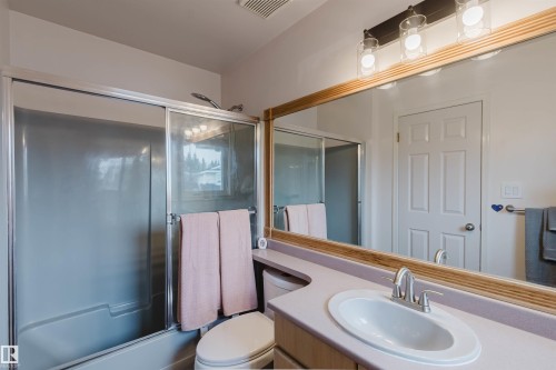 Bathroom featuring a built-in vanity with an integrated sink, a large wall-mounted mirror, and a three-light fixture - 342 O'Connor Close, Edmonton, AB - Indoor Photo Showing Bathroom