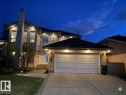 Stucco exterior with stone accents, featuring a large two-car garage, prominent chimney, and a multi-pane glass entry door - 342 O'Connor Close, Edmonton, AB  - Outdoor 