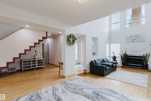Spacious living area featuring high ceilings, large windows, and light wood-finish flooring - 342 O'Connor Close, Edmonton, AB - Indoor Photo Showing Living Room With Fireplace