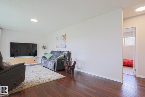 Expansive living area featuring rich wood-finish flooring, white walls, and recessed ceiling lighting - 9523 151 Street, Edmonton, AB - Indoor Photo Showing Living Room