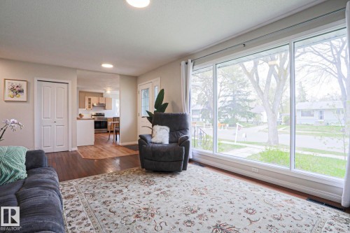 Expansive living space featuring a large picture window, wood-finish flooring, and recessed lighting - 9523 151 Street, Edmonton, AB - Indoor Photo Showing Living Room