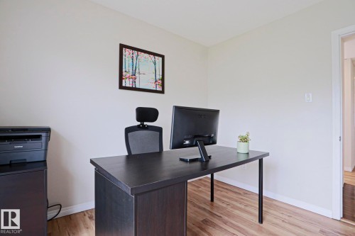 Spacious room featuring light-toned walls, wood-finish flooring, and white baseboards - 9523 151 Street, Edmonton, AB - Indoor Photo Showing Office