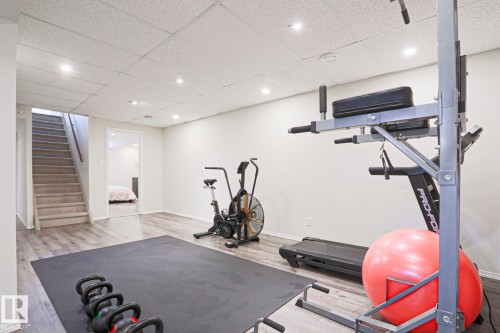 Spacious recreation room featuring recessed lighting, light wood-finish flooring, and a drop ceiling - 9523 151 Street, Edmonton, AB - Indoor Photo Showing Gym Room