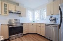 Kitchen featuring light-toned cabinetry, stainless steel appliances, and wood-finish flooring - 9523 151 Street, Edmonton, AB  - Indoor Photo Showing Kitchen 