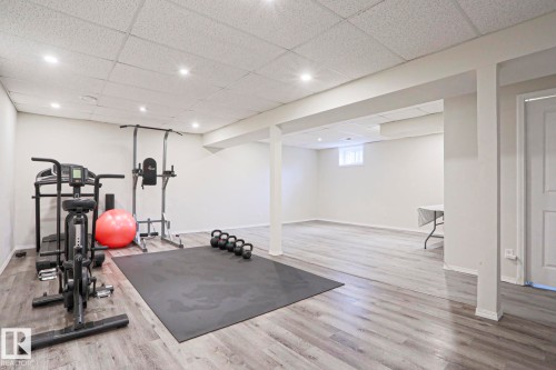 Spacious lower level featuring wood-finish flooring, recessed lighting, and a drop ceiling - 9523 151 Street, Edmonton, AB - Indoor Photo Showing Gym Room